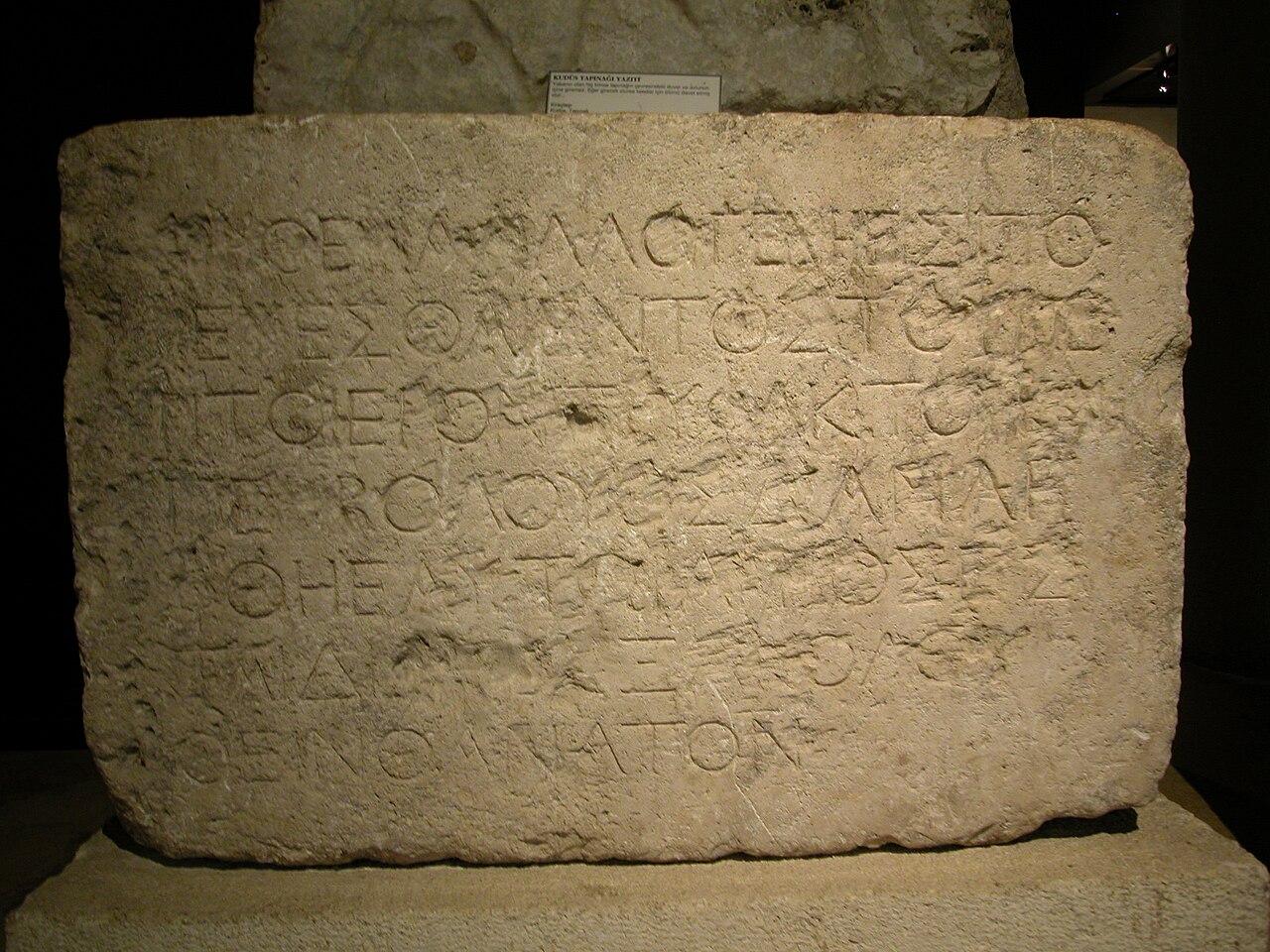 The complete Temple Warning inscription in the Istanbul Archaeology Museums — a rectangular limestone block carved with seven lines of Greek capitals.
