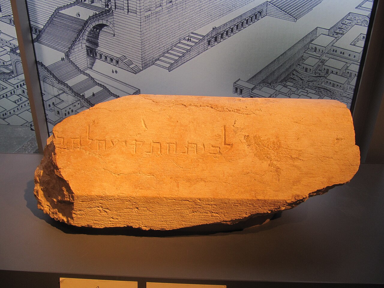 The Trumpeting Place inscription in the Israel Museum — a long ashlar with a carved parapet groove, bearing the incised square Hebrew words "lebeit hatekiah lehakh…", the end of the line broken away.
