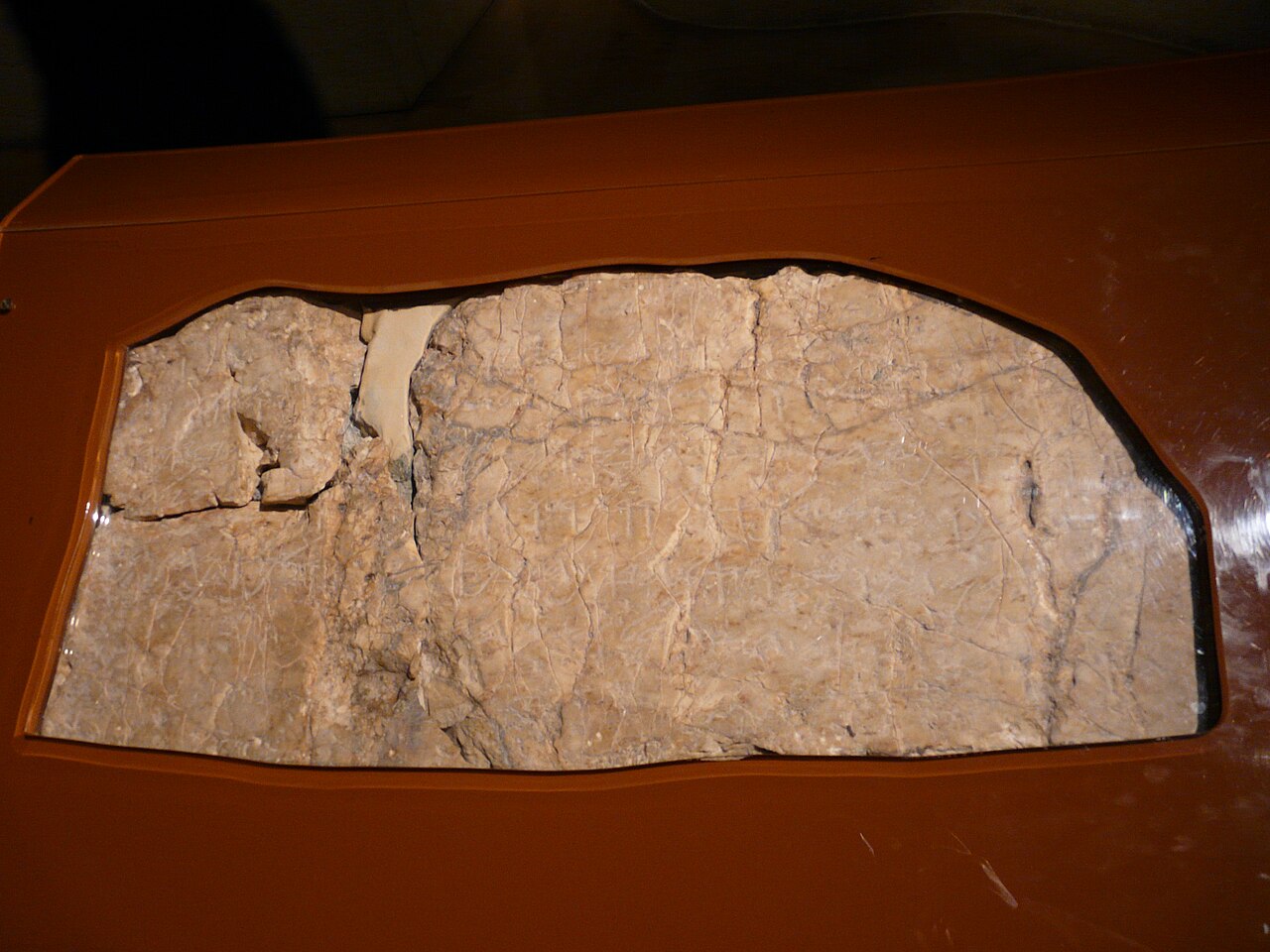 The Siloam inscription in the Istanbul Archaeology Museums — a smoothed panel of rock bearing six worn lines of paleo-Hebrew script, its lower edge broken where it was cut from the tunnel wall.
