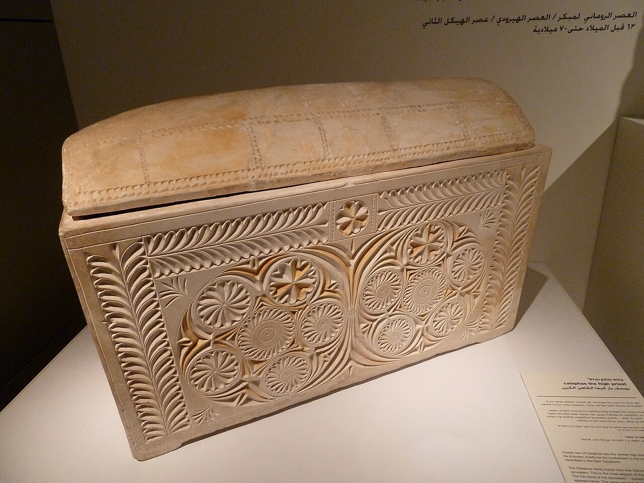 The Caiaphas ossuary in the Israel Museum — a limestone bone-box richly carved with two large rosette medallions inside incised borders.
