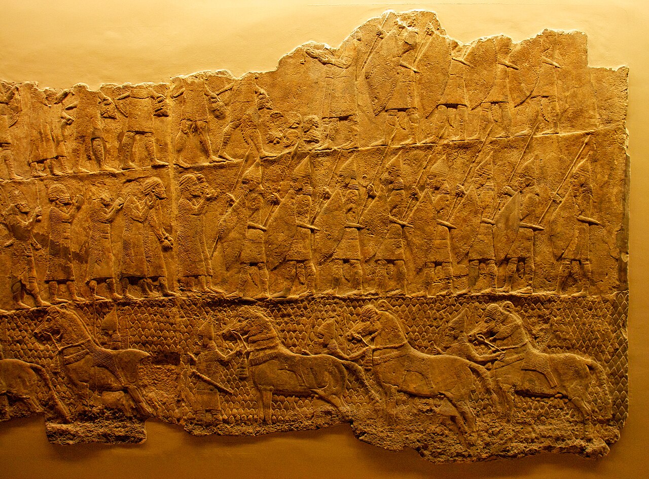 A panel of the Lachish reliefs in the British Museum — registers of Assyrian spearmen and cavalry advancing on Lachish, carved in alabaster.
