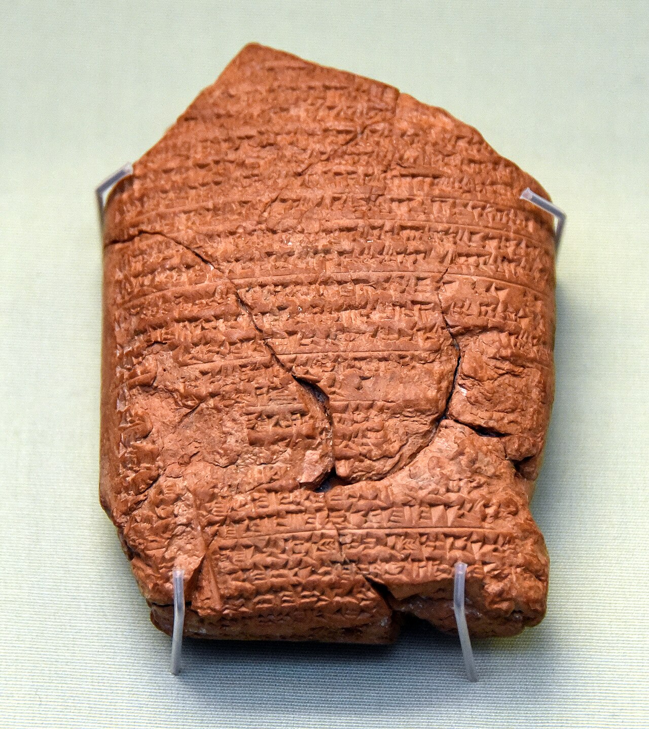Babylonian Chronicle tablet BM 21946 — a small reddish clay tablet, cracked and chipped, densely inscribed with cuneiform, mounted on display.
