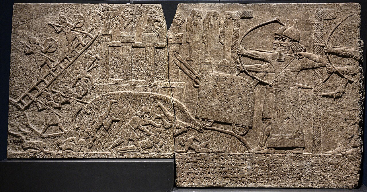 Relief of Tiglath-Pileser III's army assaulting a walled town, from the Central Palace at Nimrud, in the British Museum — siege engines, archers, and defenders on the ramparts carved in gypsum.
