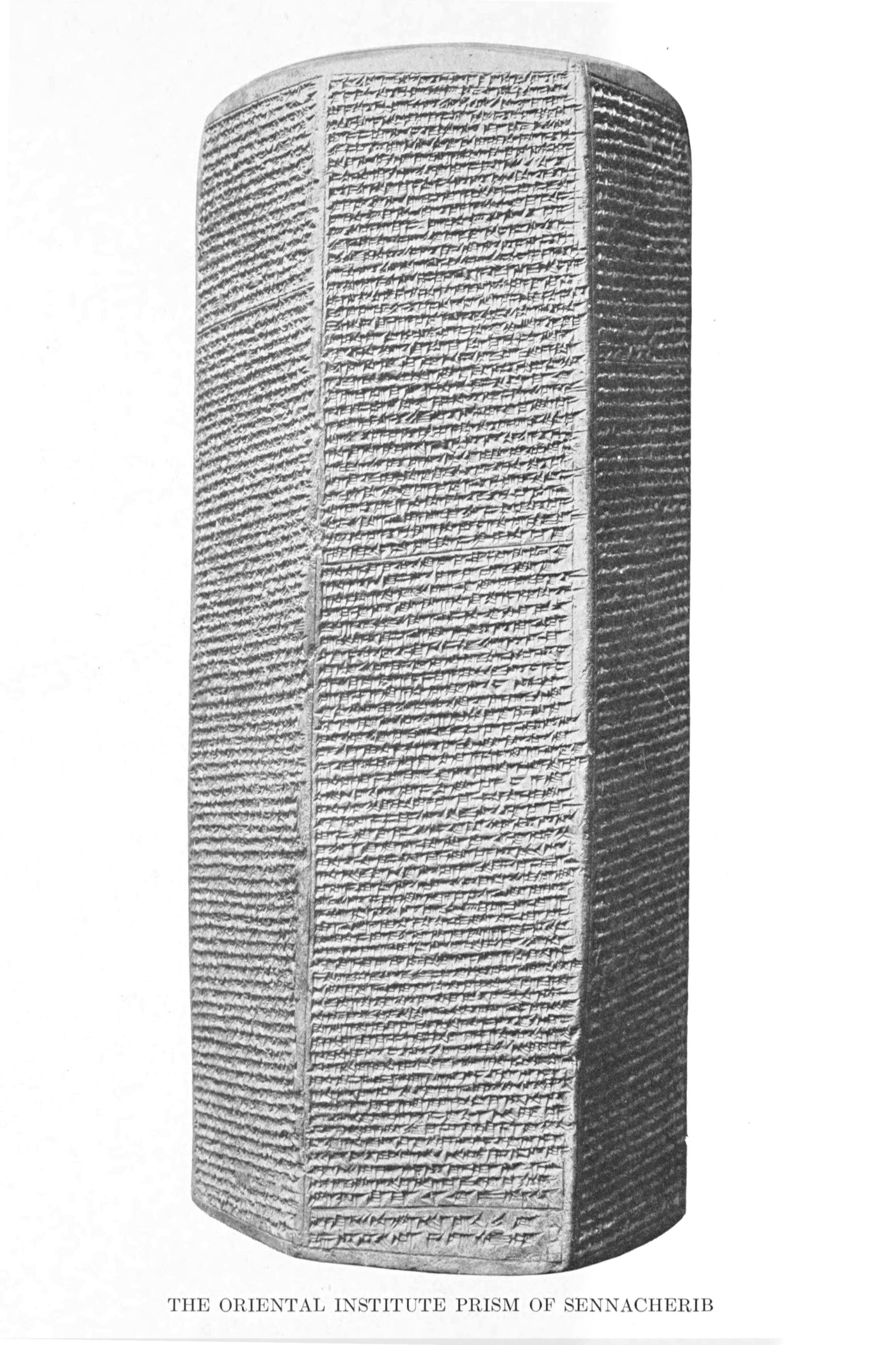 The Chicago Prism of Sennacherib — a tall six-sided baked-clay prism, every visible face covered in dense lines of cuneiform, in the plate photograph from Luckenbill's 1924 edition.
