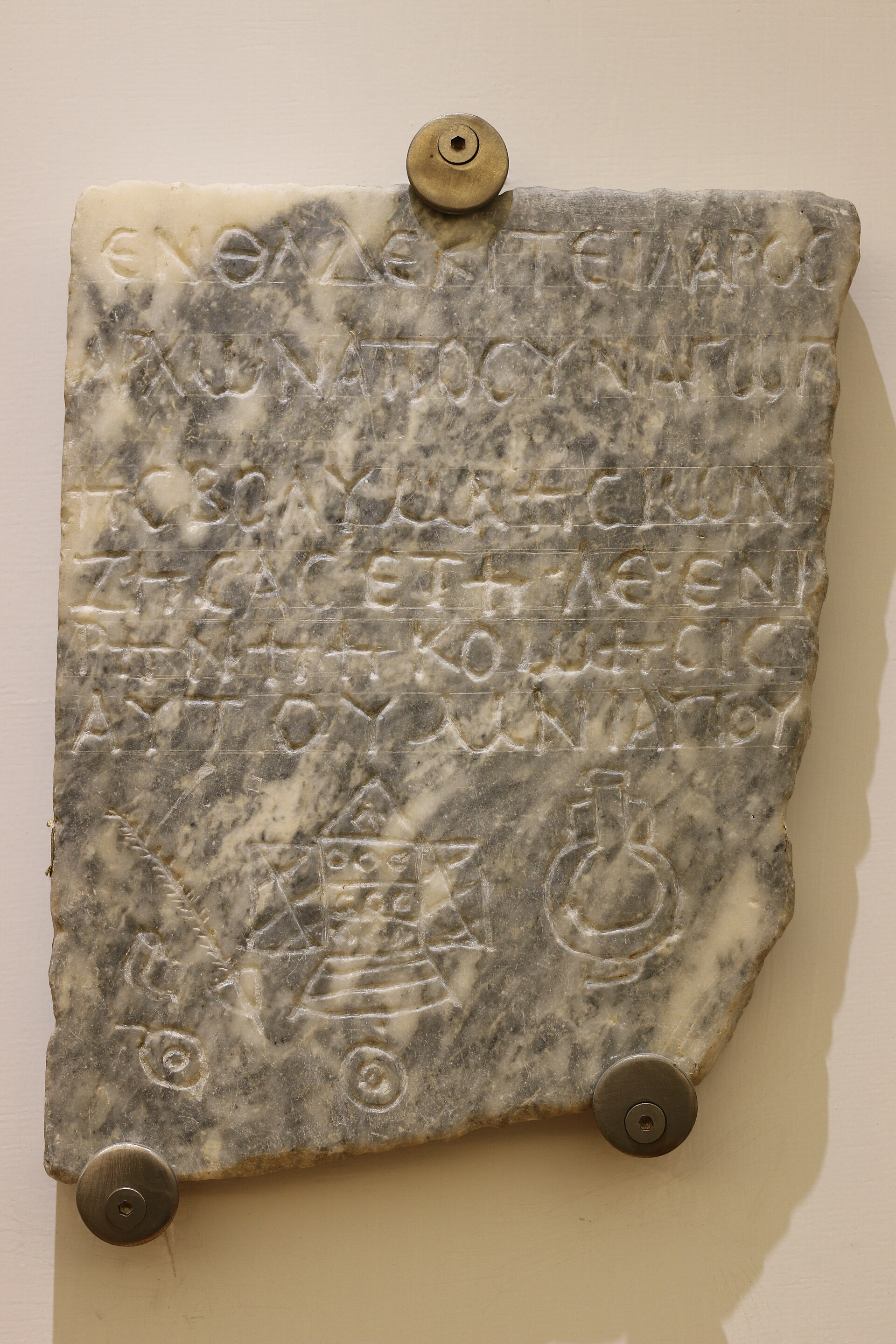 The marble funerary slab of Hilarus, archon of the Volumnesians synagogue, from the Monteverde catacomb — a Greek epitaph above carved Jewish symbols including a Torah ark, shofar, and lulav — displayed at the Baths of Diocletian, Rome.
