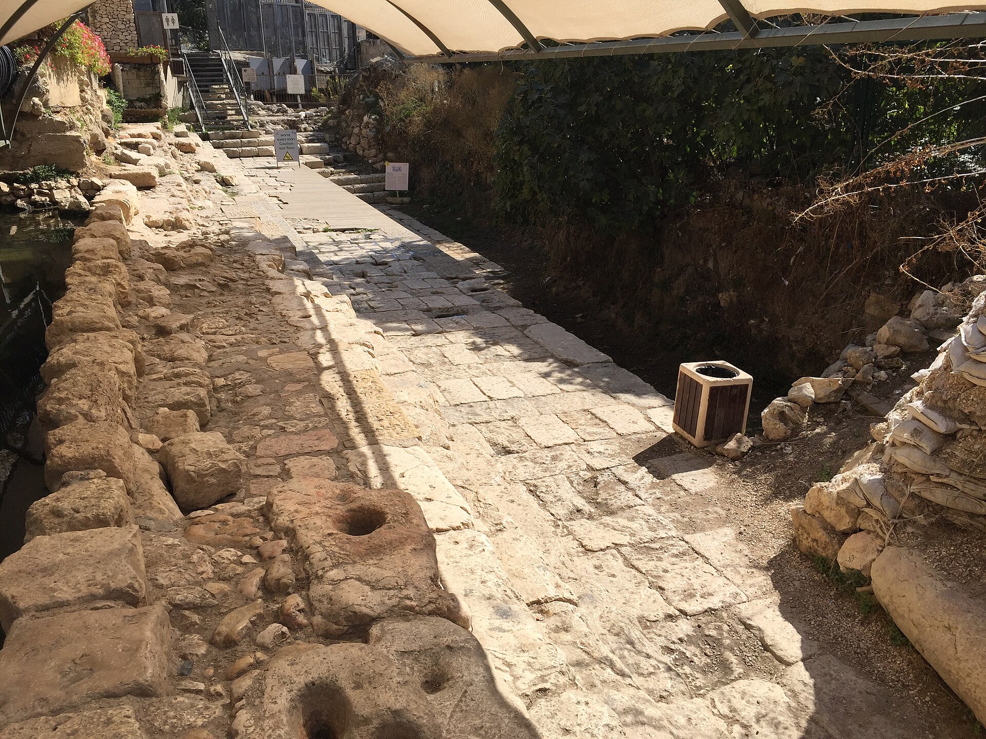 The excavated remains of the Second Temple Pool of Siloam — broad stone steps and landings descending toward the pool floor, in the City of David.
