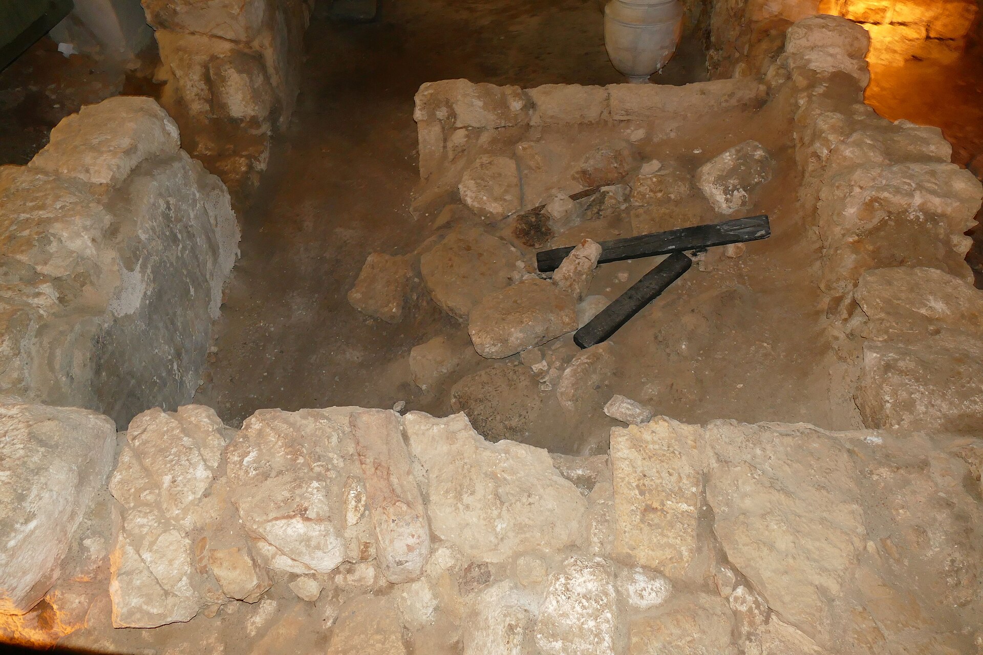 The excavated basement of the Burnt House beneath the Jewish Quarter — stone walls, ovens, and vessels of the destroyed priestly residence, preserved as a museum.
