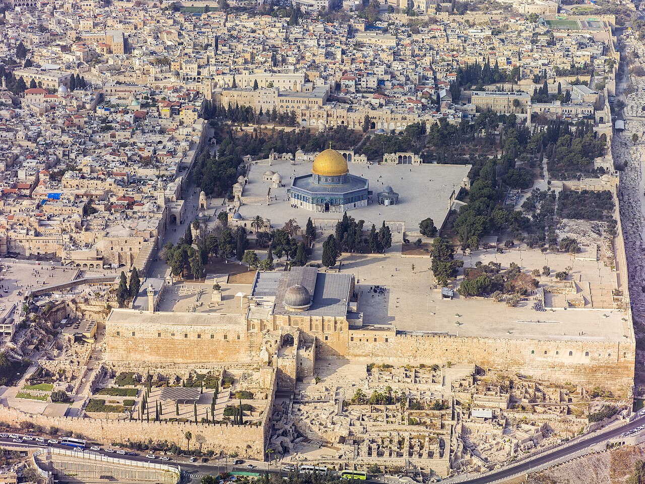 Aerial view of the Old City of Jerusalem from the south — the Temple Mount platform on its Herodian retaining walls, the Western Wall plaza at its western foot, and the excavated ruins of the Ophel and City of David in the foreground.
