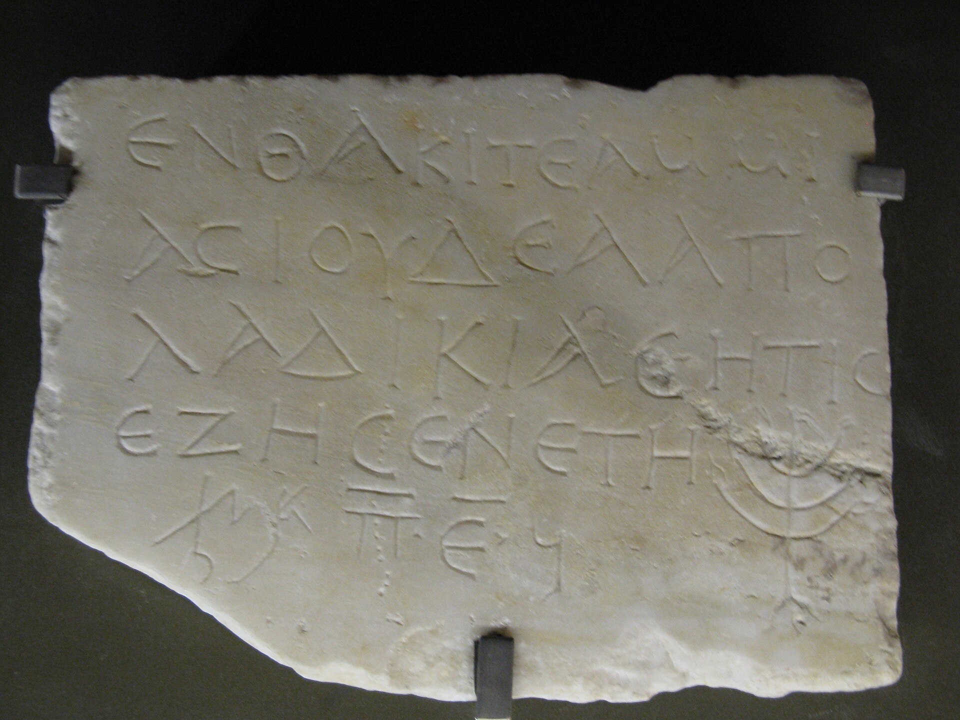 A marble epitaph from the Monteverde catacomb — the gravestone of Ammias, a Jewess from Laodicea, inscribed in Greek and a Semitic script with an engraved seven-branched menorah — now in the Capitoline Museums.
